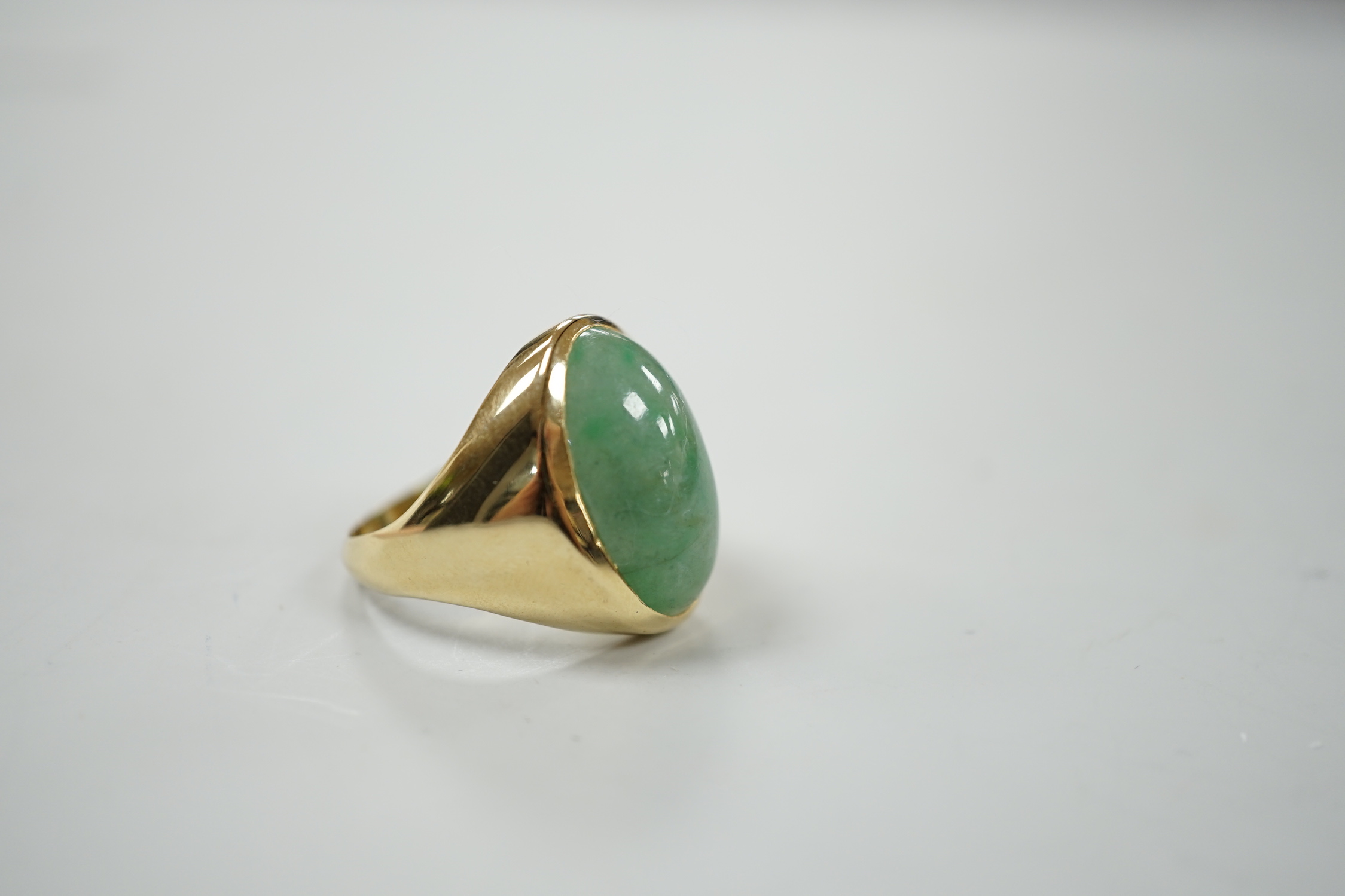 A modern 18ct gold and cabochon oval jade set ring, size P, gross weight 8.8 grams.